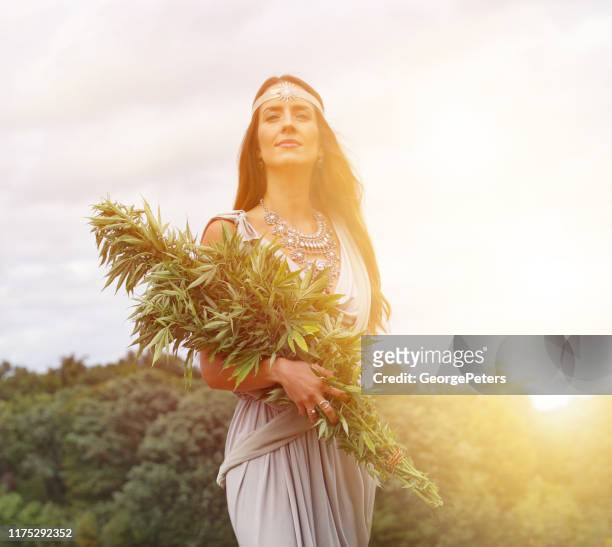 cannabis goddess holding bundle of cannabis plants - goddess stock pictures, royalty-free photos & images