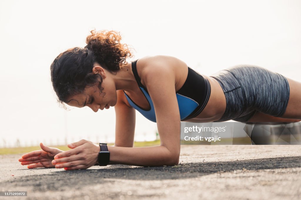 Sporty Woman Doing Plank Exercise At Park