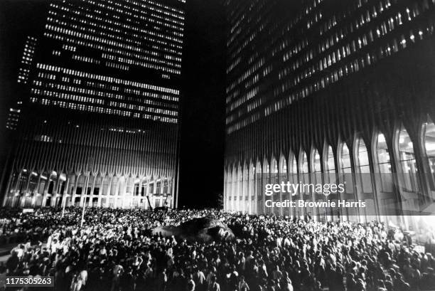 Scene from the film 'King Kong' depicts a crowd gathered around the titular character at the foot of the World Trade Center, New York, New York, 1976.