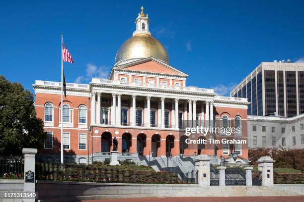 Massachusetts State House the seat of Government, with golden dome and patriotic Stars and Strips flag in the city of Boston, United States.