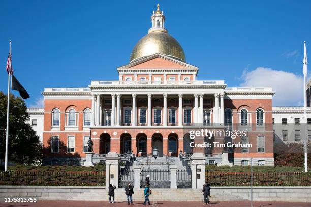 Tourists at Massachusetts State House seat of Government, with golden dome and patriotic Stars and Strips flag in Boston, United States.