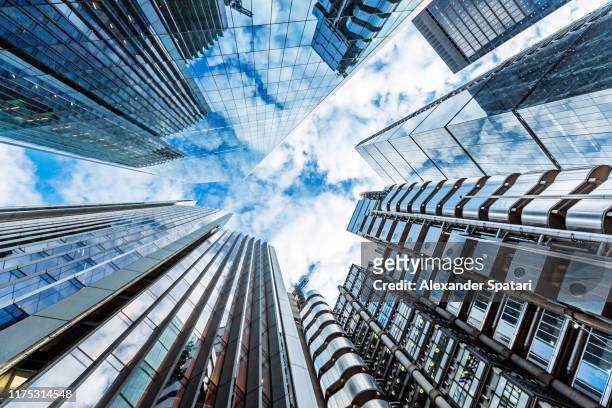 low angle view of modern futuristic skyscrapers in the city of london, england, uk - skyscraper stock pictures, royalty-free photos & images