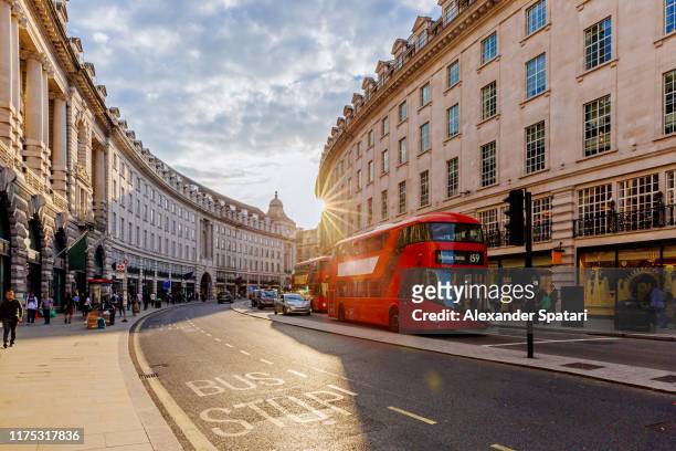 regent street  with sun shining through buildings during sunset, london, england, uk - london england stock-fotos und bilder