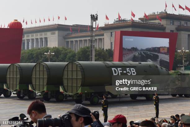 Military vehicles carrying DF-5B intercontinental ballistic missiles participate in a military parade at Tiananmen Square in Beijing on October 1 to...