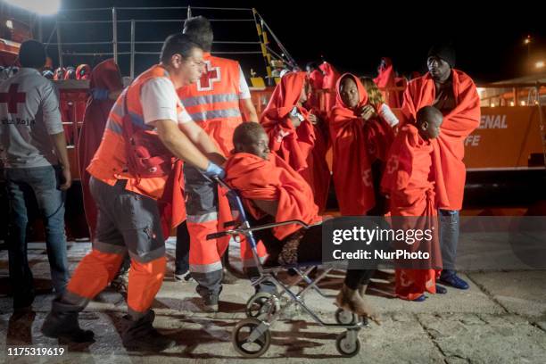 Rescued woman, seated in a wheel chair, is being attended by the Red Cross staffs at the Malaga's harbour, in Malaga, southern of Spain, on October...