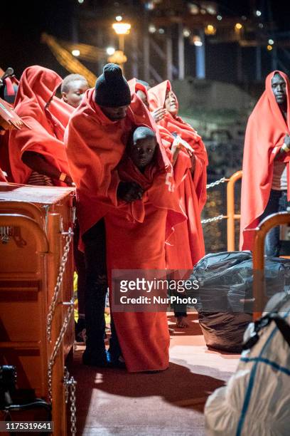 Man standing with his young boy waits onboard the Spanish Maritime vessel, to disembark, in Malaga, southern of Spain, on October 9, 2019.