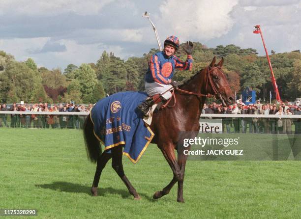 Le jockey irlandais Mick Kinane montant Montjeu salue le public, le 03 octobre 1999 à l'hippodrome de Longchamp à Paris, après avoir remporté la 78e...