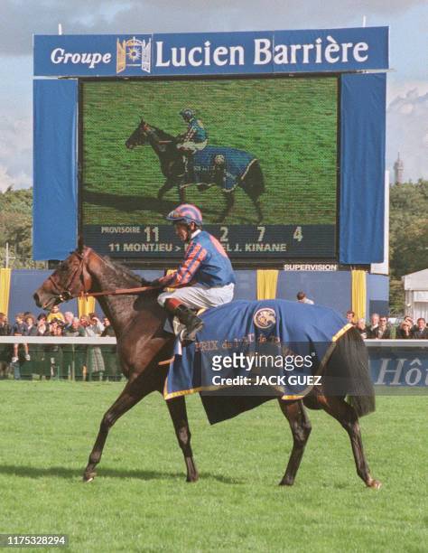 Le jockey irlandais Mick Kinane montant Montjeu fait un tour d'honneur, le 03 octobre 1999 à l'hippodrome de Longchamp à Paris, après avoir remporté...