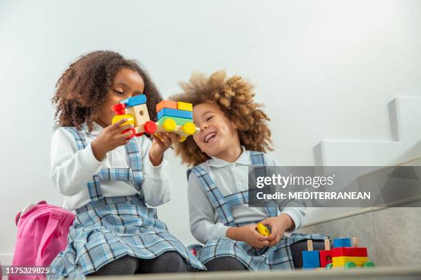 ethnic sisters playing with wooden train - twin girls stock pictures, royalty-free photos & images