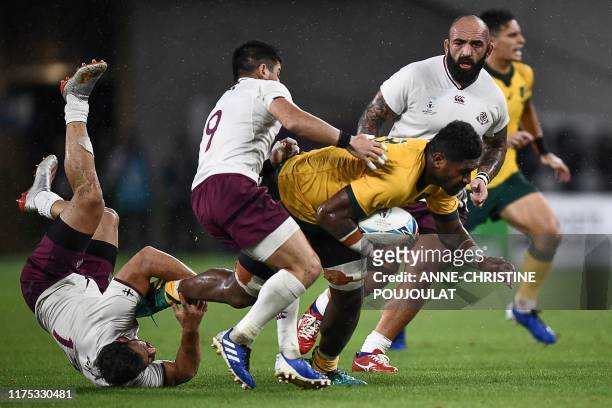 Australia's number 8 Isi Naisarani is tackled by to evade Georgia's centre Davit Kacharava and Georgia's scrum-half Gela Aprasidze during the Japan...