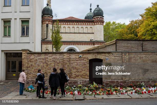 People mourn in front of the entrance to the Jewish synagogue two days after a shooting left two people dead on October 11, 2019 in Halle, Germany....