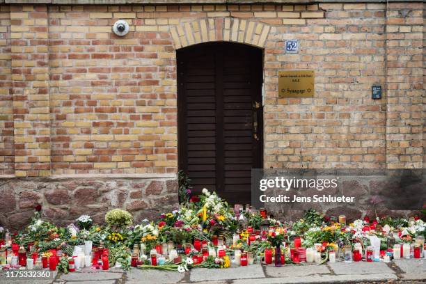 Flowers and candles are left in front the Jewish synagogue two days after a shooting left two people dead on October 11, 2019 in Halle, Germany....