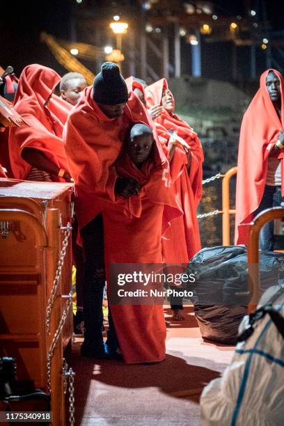 Man standing with his young boy waits onboard the Spanish Maritime vessel, to disembark, in Malaga, southern of Spain, on October 9, 2019.