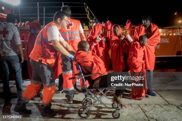 Rescued woman, seated in a wheel chair, is being attended by the Red Cross staffs at the Malaga's harbour, in Malaga, southern of Spain, on October...