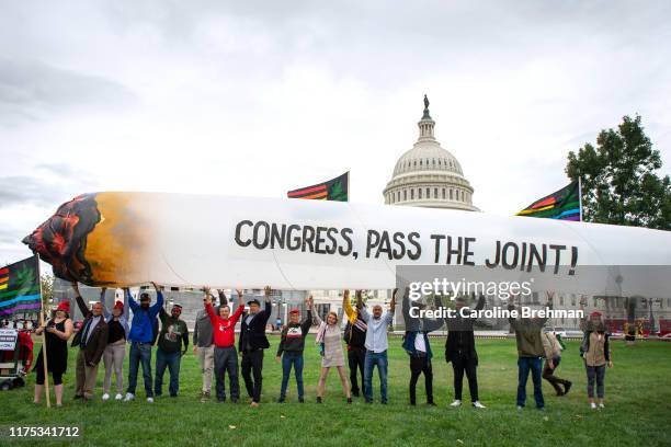 Marijuana activists hold up a 51-foot inflatable joint during a rally at the U.S. Capitol to call on Congress pass cannabis reform legislation on...