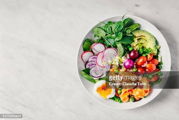 healthy lunch bowl with greens, avocado, cherry tomatoes, radish, boiled egg, and shrimp on white background - salad bowl stock pictures, royalty-free photos & images
