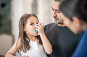 Preschool age girl with asthma learns to use an inhaler