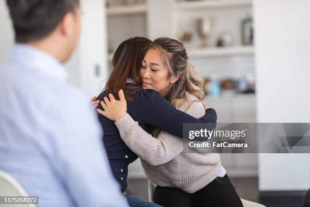 two women hug in therapy session - victim advocacy stock pictures, royalty-free photos & images