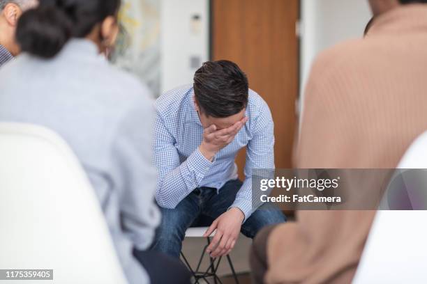 man crying in group therapy session - victim assistance stock pictures, royalty-free photos & images