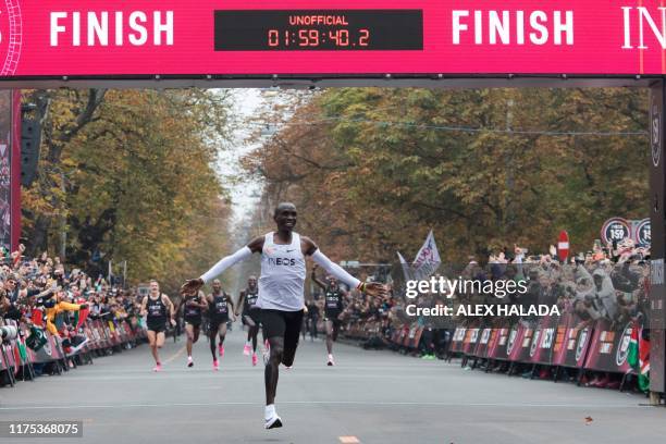 Kenya's Eliud Kipchoge celebrates as he crosses the finish line at the end of his attempt to bust the mythical two-hour barrier for the marathon on...