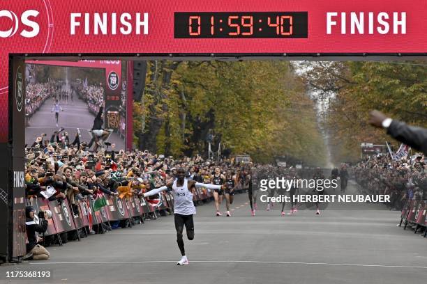 Kenya's Eliud Kipchoge celebrates as he crosses the finish line at the end of his attempt to bust the mythical two-hour barrier for the marathon on...