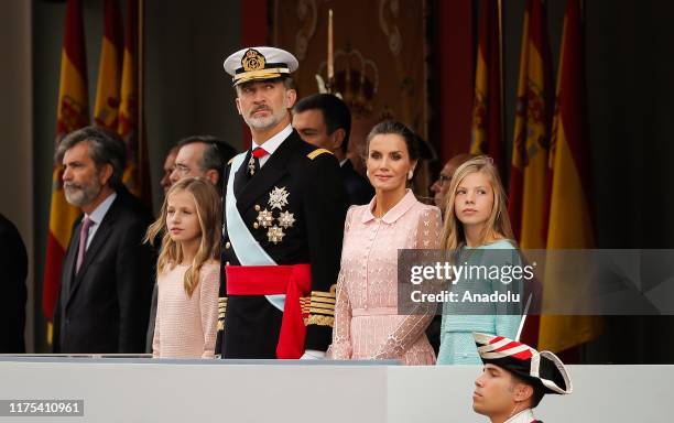 Spain's King Felipe VI and Queen Letizia stand with their children Crown Princess Leonor and Princess Sofia during the National Day, in downtown...