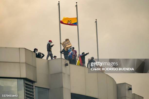 Demonstrators stand at the terrace roof of the Comptroller General's Office building after breaking in, during the 10th day of a protest over a fuel...