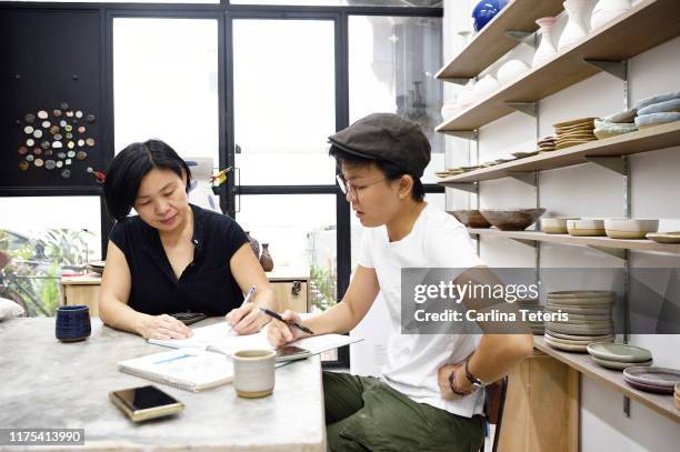 two artists having a business meeting - design studio woman chinese laptop fotografías e imágenes de stock