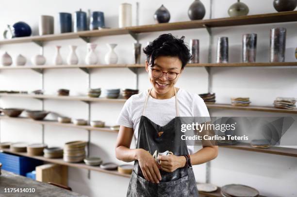 millennial woman in her ceramics shop - store studios ストックフォトと画像