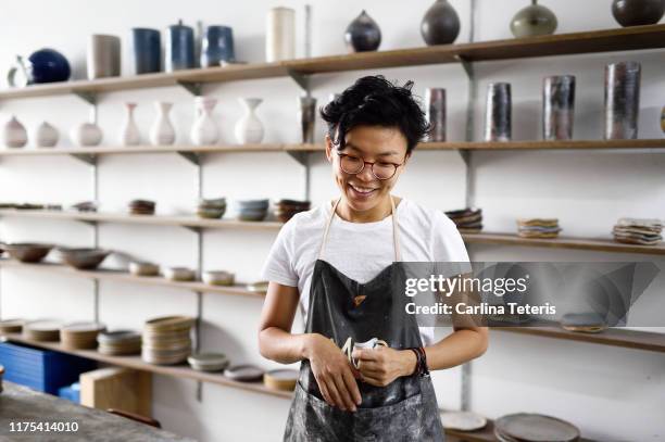 millennial woman in her ceramics shop - earthenware stock pictures, royalty-free photos & images