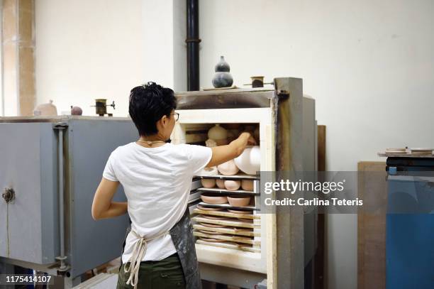 woman unloading a kiln - kiln stock pictures, royalty-free photos & images