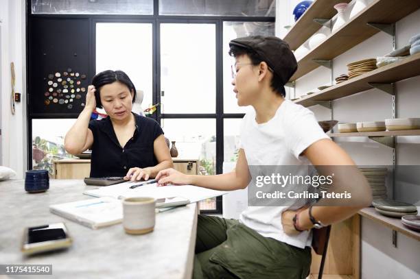 two artists having a business meeting - design studio woman chinese laptop stock pictures, royalty-free photos & images