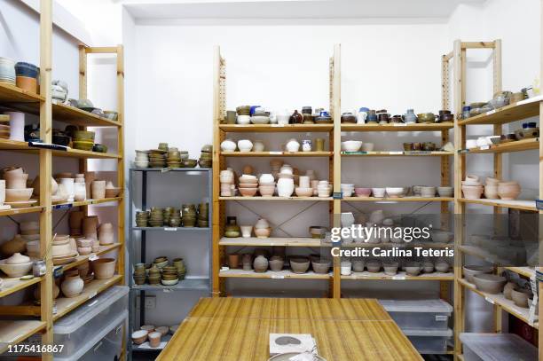 shelves of clay dishes in a ceramics studio - store studios ストックフォトと画像