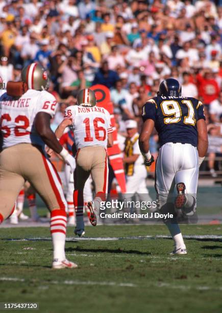 Joe Montana on a run to the left side pursued by Chargers DE Leslie O'Neal. San Francisco 49ers 48 vs San Diego Chargers 10 at Jack Murphy Stadium in...