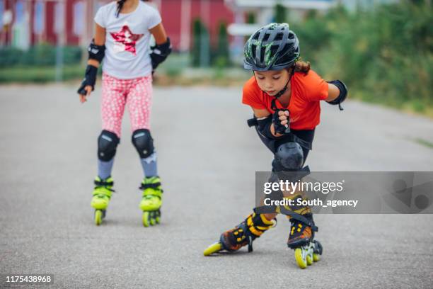 patinage à roulettes de deux jeunes filles - coudière photos et images de collection