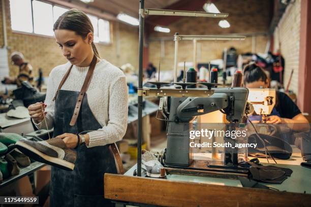 lady holding a leather shoe in shoe factory - shoe factory stock pictures, royalty-free photos & images