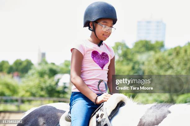 girl riding on horse at riding school - montar a caballo por placer fotografías e imágenes de stock