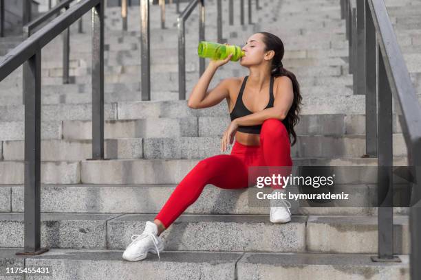 young woman sitting after run - sport drink stock pictures, royalty-free photos & images