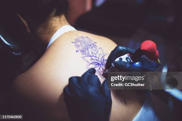 professionelle tattoo-künstler tätowierung einer frau in seinem studio - bali, indonesien - tattooing stock-fotos und bilder
