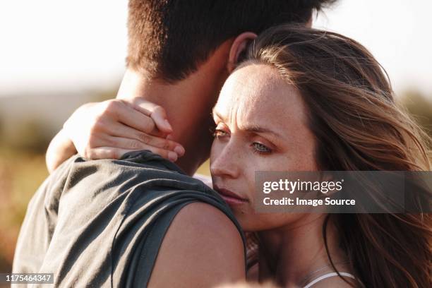 couple hugging, woman looking worried - relationship difficulties foto e immagini stock