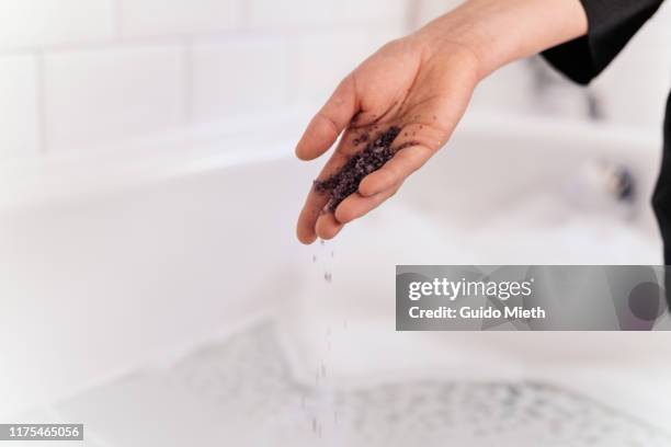 woman putting bath salt into bath tube. - bath salt stock pictures, royalty-free photos & images
