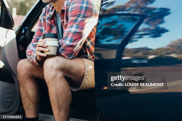 aussie bloke enjoys his morning coffee from an eco travel mug - leaning on elbows stock pictures, royalty-free photos & images