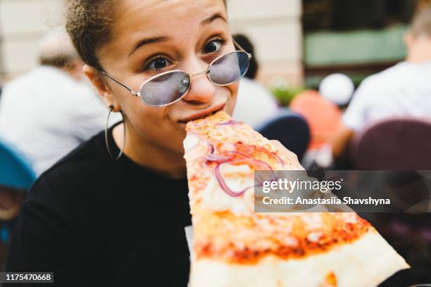 junge frau mag ihre pizza so sehr! - woman eating pizza stock-fotos und bilder