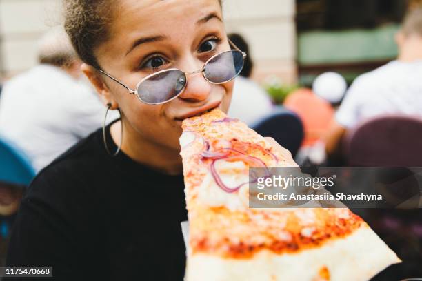 young woman likes her pizza so much! - hungry teen stock pictures, royalty-free photos & images