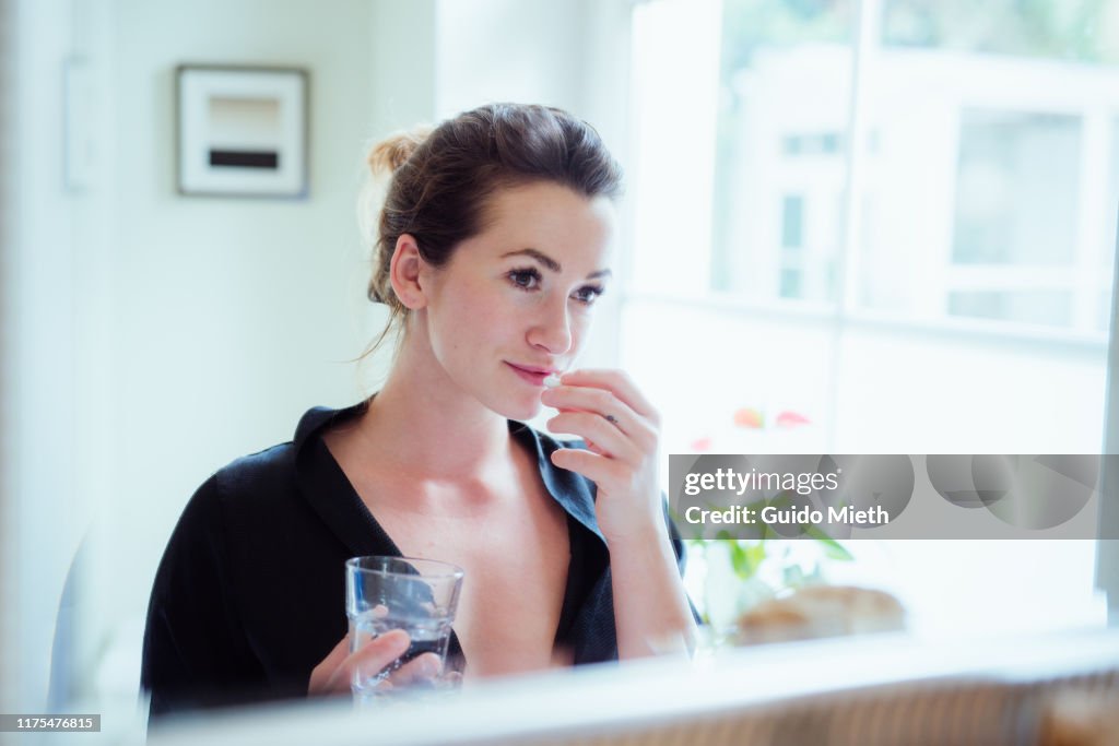 Woman taking vitamins and supplements.