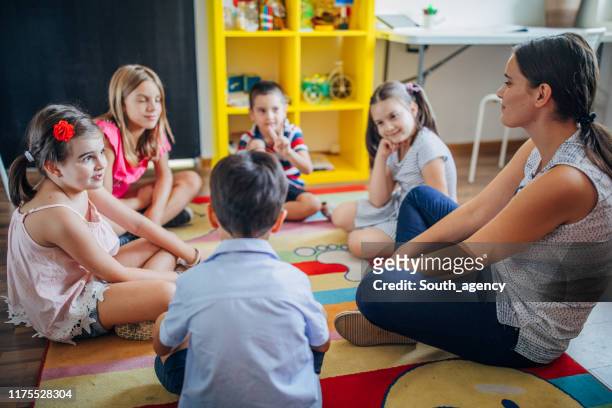 insegnanti e bambini in età prescolare - bambini seduti in cerchio foto e immagini stock