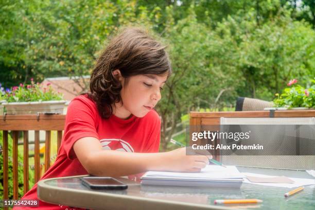 9-years-old boy drawing on a porch. - 8 9 years stock pictures, royalty-free photos & images