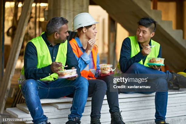multi-ethnic coworkers eating lunch at site - construction lunch stock pictures, royalty-free photos & images