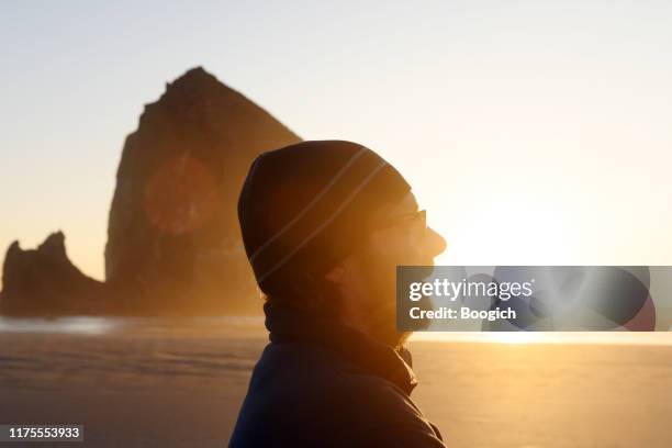 close up of man walking cannon beach oregon at sunset - famous faces stock pictures, royalty-free photos & images