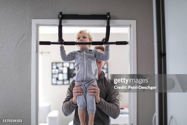 a toddler playing on an exercise mat at home. - chin ups stock pictures, royalty-free photos & images